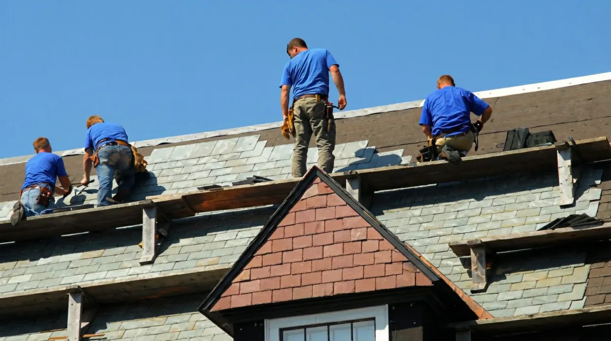 Roof replacement in progress with a team of professional contractors installing new shingles on a residential home in Omaha, NE